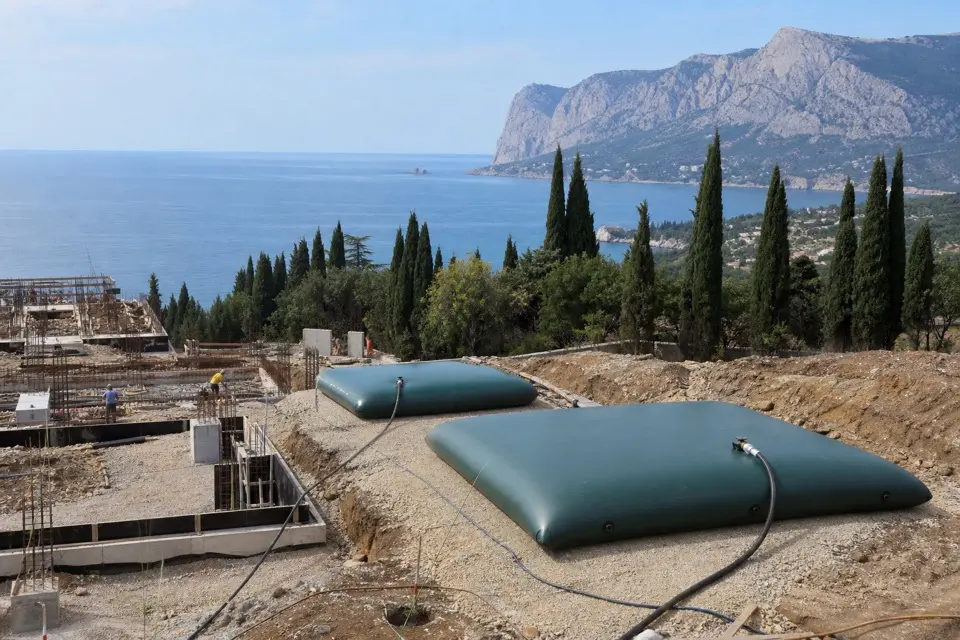 Строительная площадка в Крыму: временные ёмкости на фоне моря и кипарисов